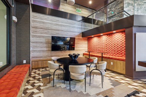 a dining area with a table and chairs and a television at Link Apartments® Broad Ave, Tennessee